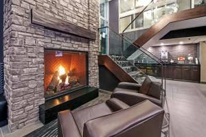 a living room with a fireplace and a fire place at Best Western Plus Siding 29 Lodge in Banff