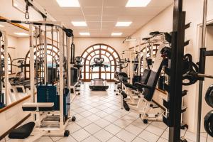 une salle de sport avec plusieurs tapis de course et machines dans l'établissement Hotel Carasco, à Lipari