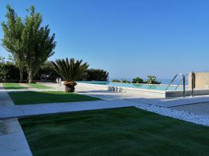 einen Gehweg mit Pool und Gras in der Unterkunft Villa Eleonora in Marina di Ragusa