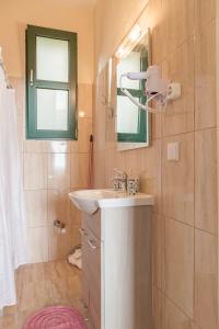 uma casa de banho com um lavatório e um espelho em Rising Sun studios - Old Town em Xanthi