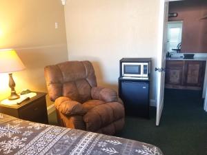 a brown chair in a room with a microwave at Lily Pad Suites in Andrews