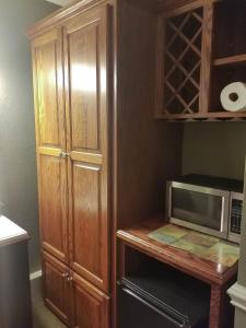 a kitchen with a microwave and a wooden cabinet at Lily Pad Suites in Andrews