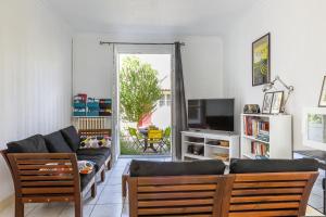 a living room with a couch and a tv at Maison 88 m2 le patio du centre ville avec garage in Tours