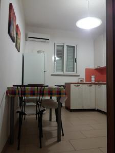uma cozinha com mesa e cadeiras num quarto em Casa Ida em Donnalucata