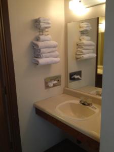 y baño con lavabo, espejo y toallas. en Budget Inn en Green River