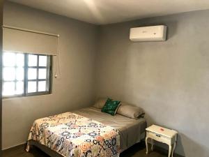 um pequeno quarto com uma cama e ar condicionado em CASA MALIX Puerto Morelos em Puerto Morelos