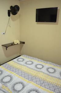 um quarto com uma cama e uma televisão na parede em #5 Private room close to Airport em Alajuela