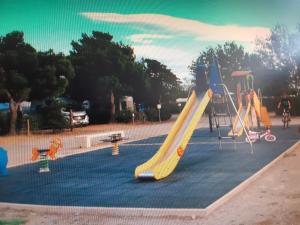 a playground with a slide in a park at chez paulette 75 in Port-la-Nouvelle