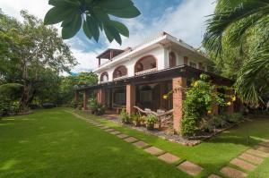 ein Backsteinhaus mit einem grünen Hof in der Unterkunft Amihan-Home in Boracay