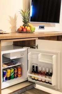 an open refrigerator with drinks and a bowl of fruit at Sunset hotel & beach in Dobra Voda