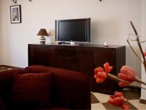 een woonkamer met een bank en een tv bij Casa Rural el Reencuentro "Grupo Mirando a Gredos" in Cadalso de los Vidrios