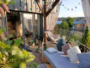 a balcony with a blue couch and some plants at Apart-terrace on Baker Street in Lviv