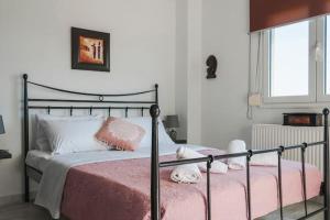 una camera da letto con un letto con lenzuola rosa e una finestra di Sea View Maisonette in Chania a Chania