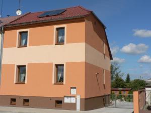 un gran edificio naranja con techo rojo en Penzion Pohůrka, en České Budějovice