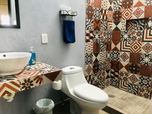 La salle de bains est pourvue de toilettes, d'un lavabo et de carrelage. dans l'établissement CASA MALIX Puerto Morelos, à Puerto Morelos