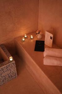 bagno con vasca, candele e asciugamani di Riad l'Oiseau du Paradis a Marrakech