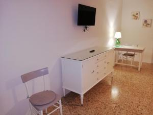 マティーノにあるDa Pippi e Gesuinaの白いドレッサー付きの部屋(壁にテレビ付)