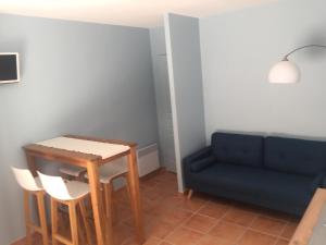 a living room with a blue couch and a table at L’oustau in Rochefort-du-Gard