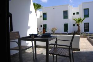 un tavolo e delle sedie seduti su un patio di Magmamia a Puerto del Carmen