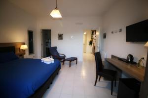 a hotel room with a blue bed and a desk and chairs at B & B LA MARMIFERA in Carrara