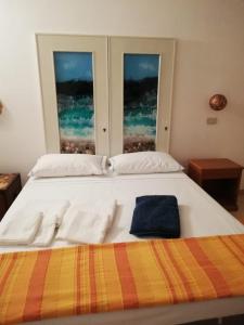 1 Schlafzimmer mit einem großen weißen Bett und 2 Fenstern in der Unterkunft Al 101...sogni... in Villa San Pietro