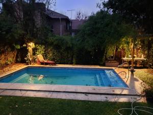 a small swimming pool in a yard with a table at Los Colibries Tigre Centro in Tigre