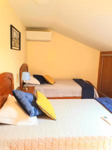 a bedroom with two beds with pillows on them at Casa Límia in Ponte de Lima