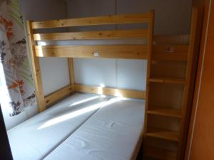 a small bedroom with a bunk bed and a book shelf at Camping Les Terrasses de Dordogne in Rouffignac Saint-Cernin +41 photos
