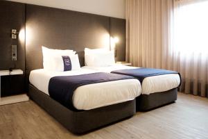 ヴィーラ・ノーヴァ・デ・ファマリカンにあるVilla Prime Hotelのベッドルーム1室(大型ベッド1台付)