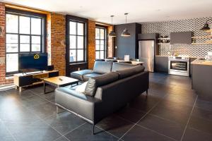 a living room with a couch and a kitchen at Les Lofts St-Vallier - Par Les Lofts Vieux Québec in Quebec City