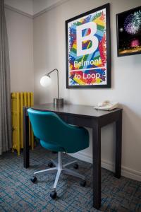 a room with a desk and a painting on the wall at City Suites Hotel in Chicago