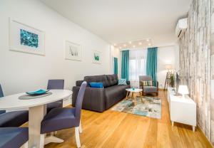 ベオグラードにあるApartman Tirenaのソファとテーブルのあるリビングルーム