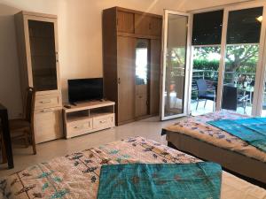a bedroom with two beds and a flat screen tv at Studio apartman Budex in Đenovići