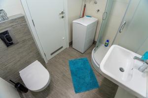 ベオグラードにあるApartman Tirenaの白いトイレと洗面台のあるバスルーム +9枚の写真