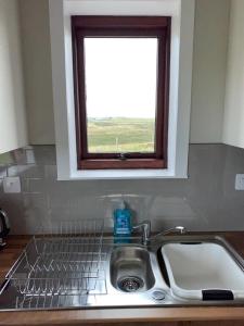 a sink in a kitchen with a window above it at 18 Cross Skigesrta Road in Swanibost