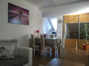 uma sala de jantar e sala de estar com mesa e cadeiras em apartman Lusy em Veľká Lomnica