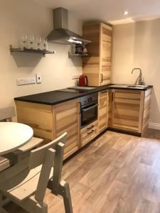a kitchen with wooden cabinets and a table and a sink at Bush House Accommodation - The Diamond in Bushmills