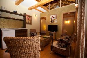 sala de estar con sillas de mimbre y TV en Villa Donna, en Trogir