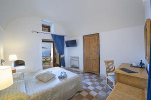 a bedroom with a bed and a desk and a table at Villa Il Frantoio and Lilmar in Praiano