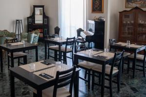 a dining room with tables and chairs and a piano at Casa del Marchese B&B in Riposto
