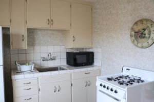 a white kitchen with a stove and a microwave at Country Inn Motel in Palo Alto