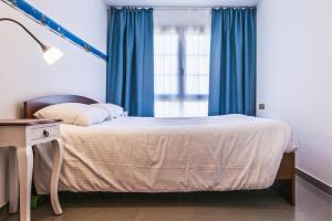 コティージョにあるCasa Galileoのベッドルーム1室(青いカーテン、窓付)