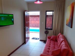 a living room with a couch and a flat screen tv at Max Garden and Pool in Paramaribo