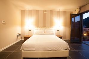 1 dormitorio con 1 cama blanca grande y 2 mesitas de noche en Roccamonfina Palace Hotel, en Roccamonfina