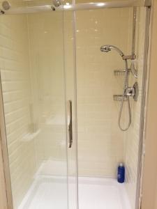 um chuveiro com uma porta de vidro na casa de banho em London Luxury Apartments 1min walk from Underground, with FREE PARKING FREE WIFI em Londres
