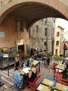 un gruppo di persone seduti ai tavoli fuori da un edificio di Old Style Studio a Perugia