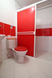 uma casa de banho com um WC e uma porta vermelha em HOTEL MANAGER OBELISK em Medellín