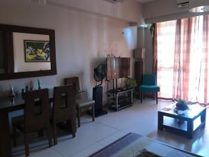 a living room with chairs and a table and a room with a tablektop at Creys condo at Pico de Loro Cove in Nasugbu