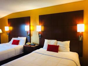 a hotel room with two beds with red pillows at Hotel M Mount Pocono in Mount Pocono