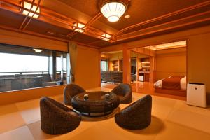 - un salon avec une table, des chaises et un lit dans l'établissement Biwako Hanakaido, à Ōtsu